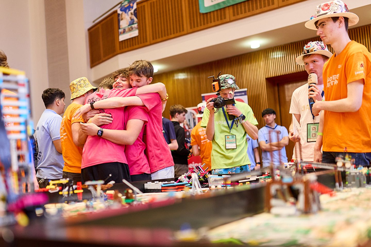 Ein Team feiert nach dem Robot Game am Spieltisch einen Moment voller Teamgeist, Freundschaft und echter Freude.