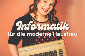 Eine lachende Frau mit einem gepunkteten Kleid hält einen Commodore 64 hoch.